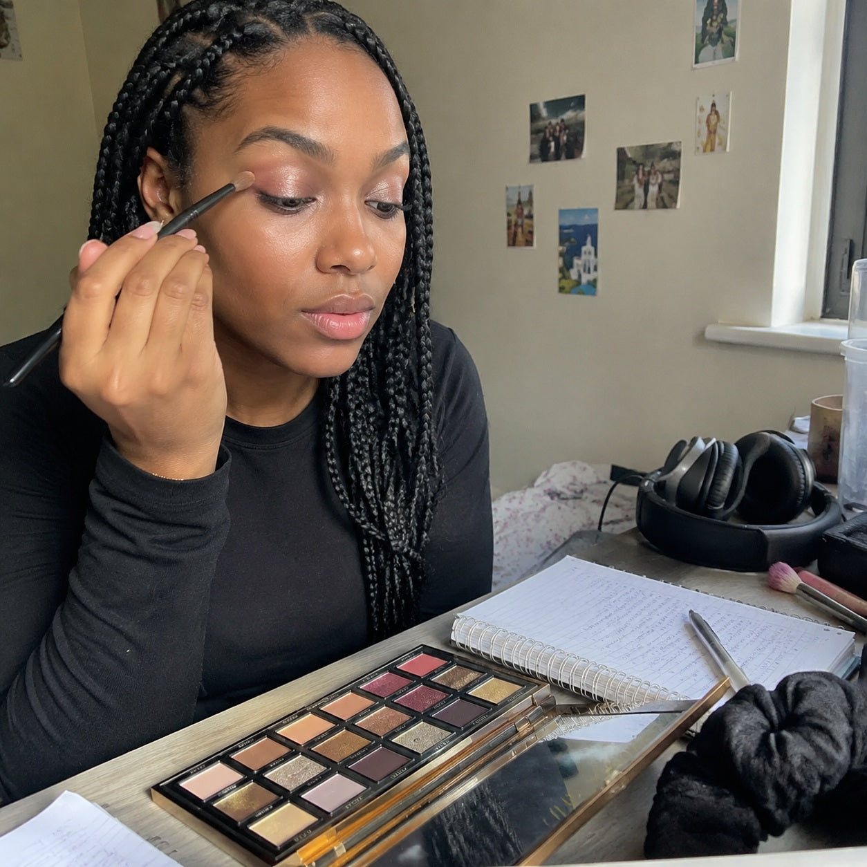 Student dorm room makeup routine with eyeshadow palette on the desk