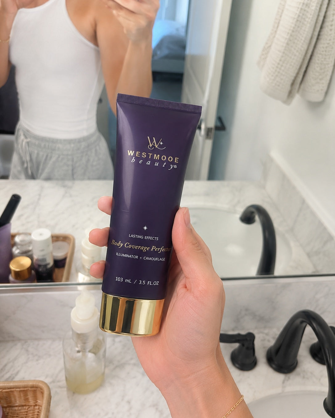 Customer holding Body Coverage Perfector in a bathroom mirror